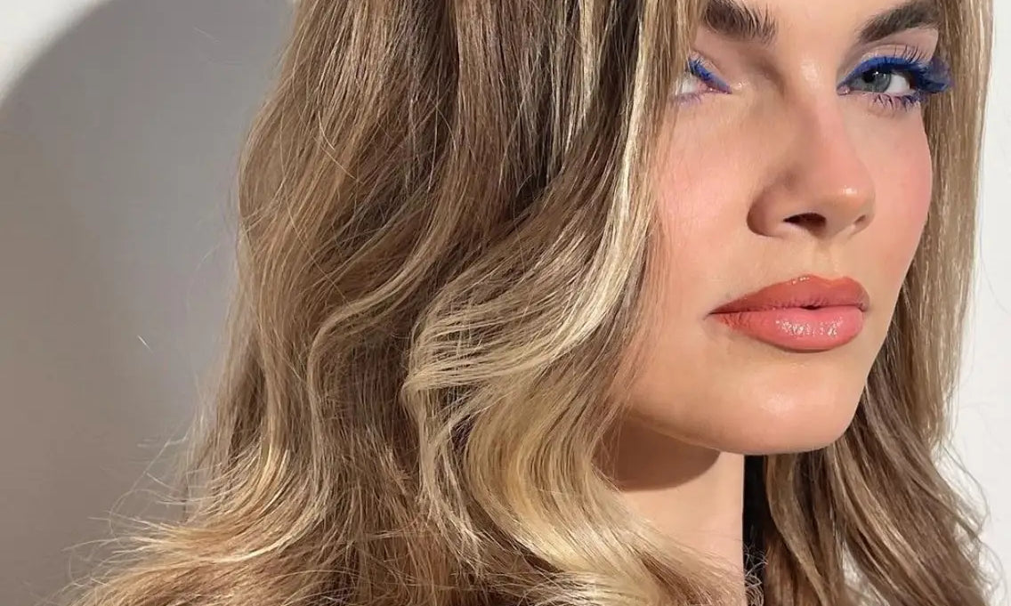 Woman looking sideways at camera with beautiful, big, bombshell waves in her blonde hair