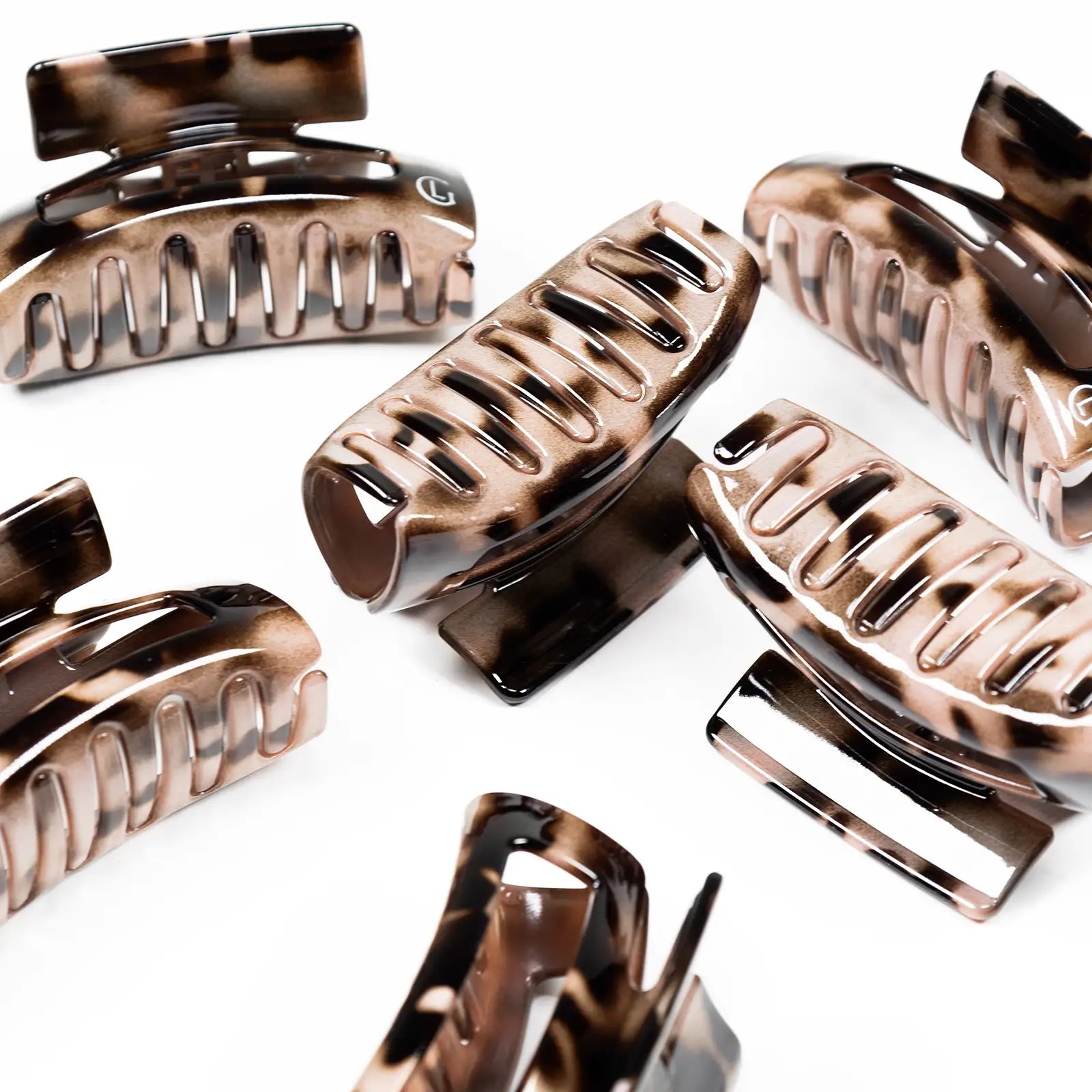 A group of tortoiseshell Leonor Greyl hair clips on white background