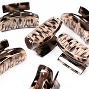 A group of tortoiseshell Leonor Greyl hair clips on white background