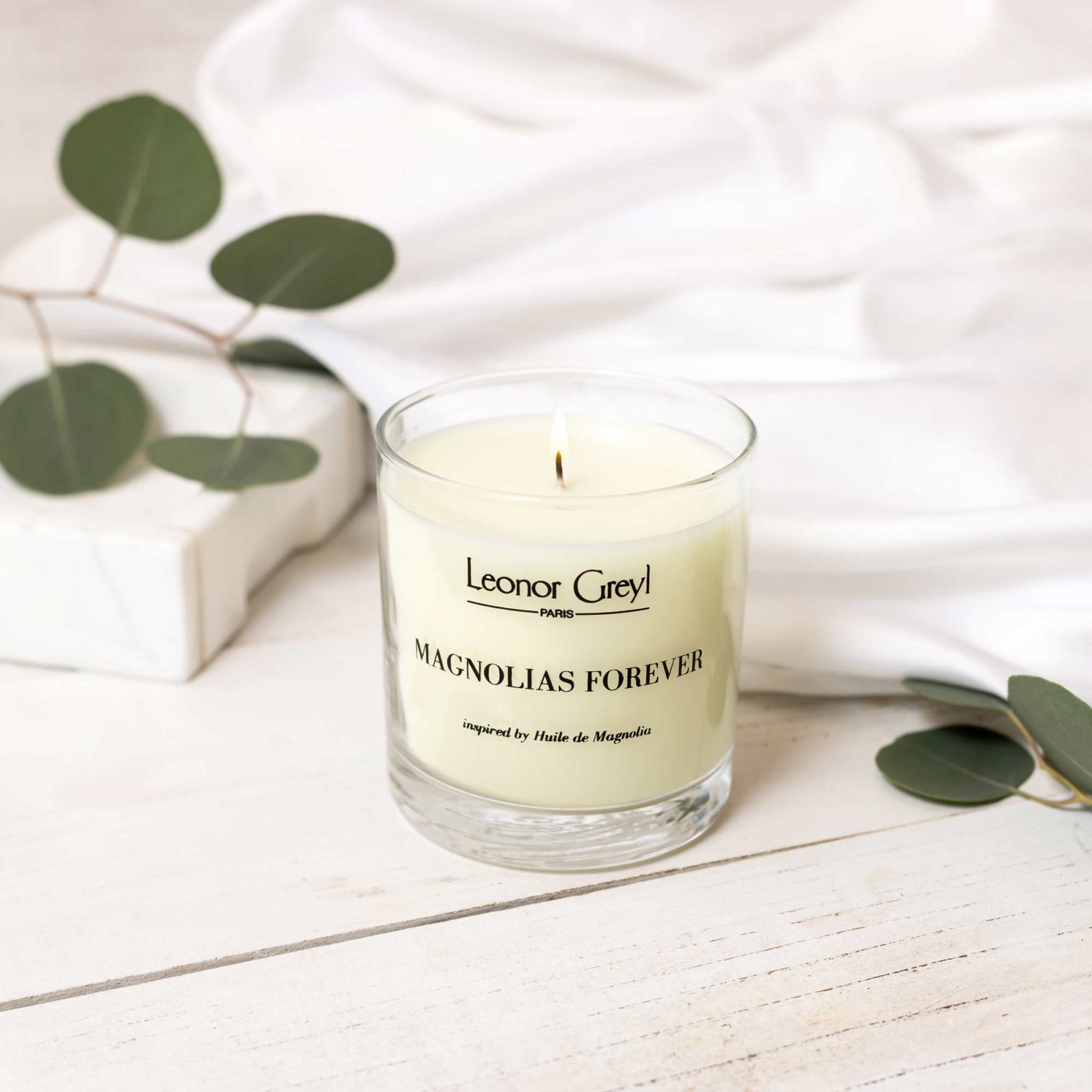 Leonor Greyl Magnolias Forever candle with white fabric & greenery