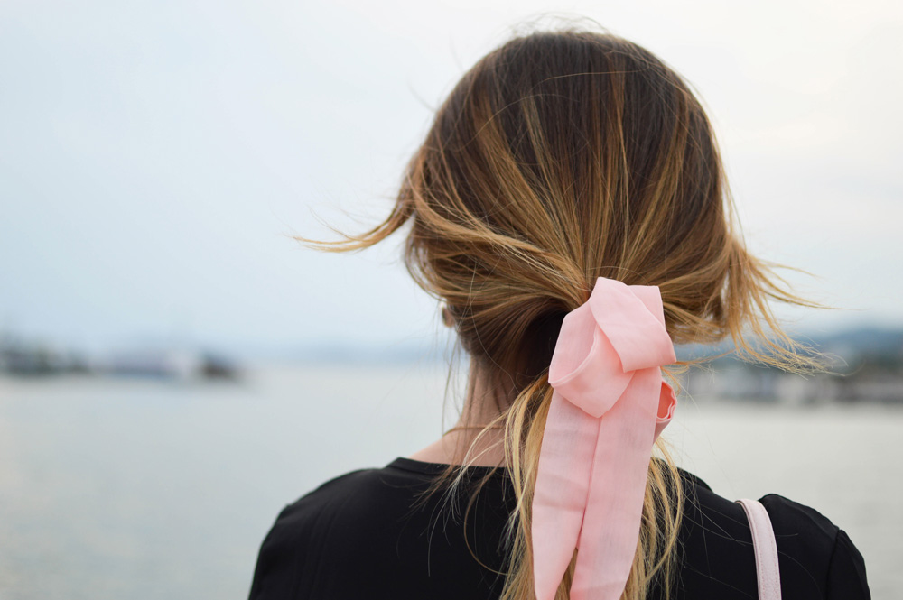 Woman’s hair with a pink ribbon