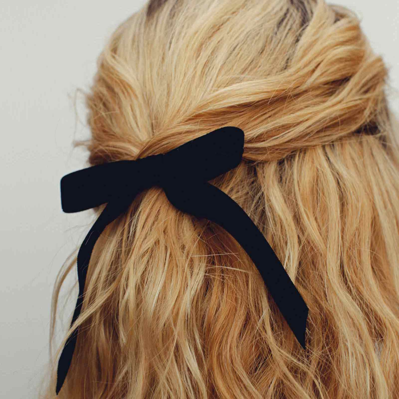 closeup of henningson black bardot bow in wavy blonde hair