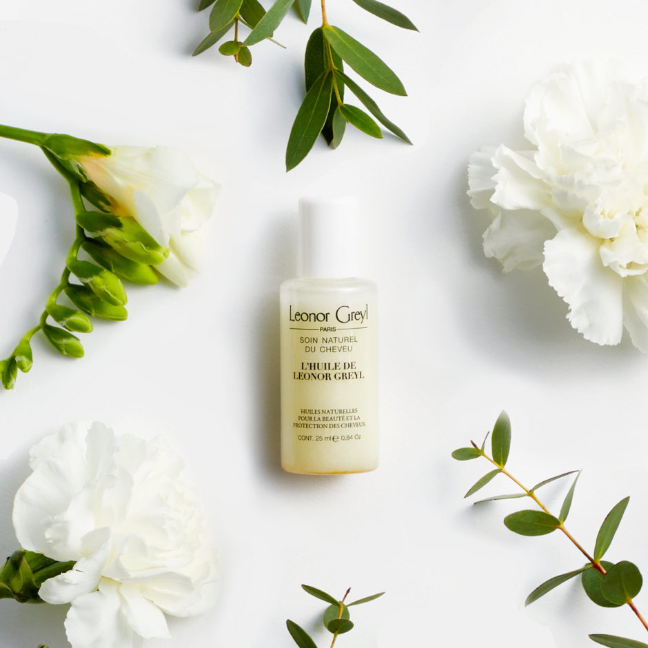 l'huile de leonor greyl travel size with white flowers and greenery