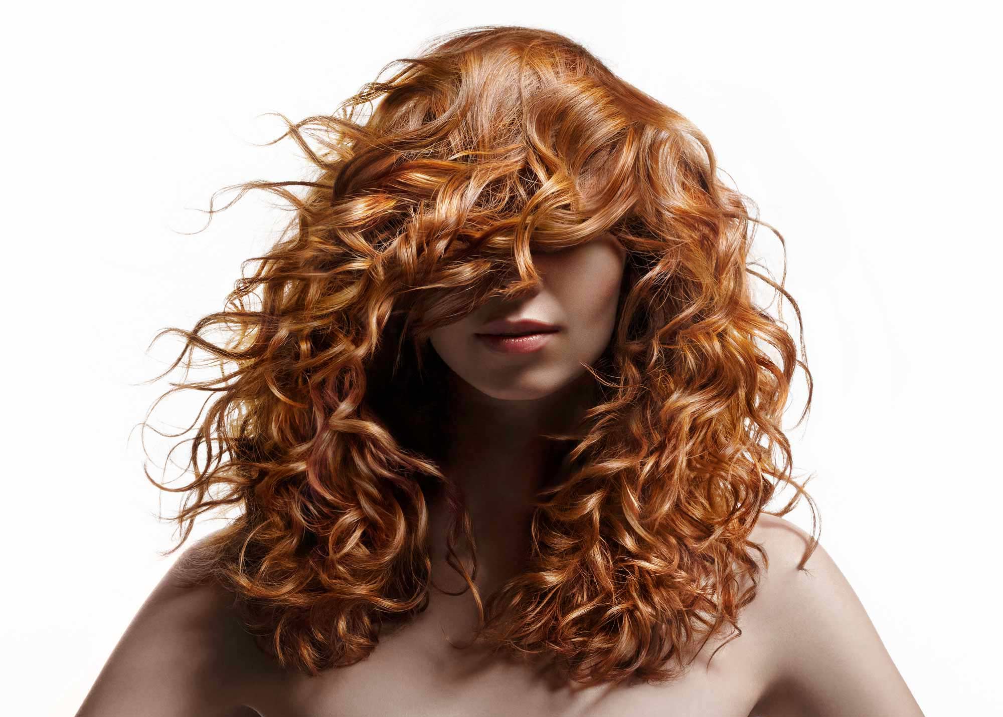 model with gorgeous red curly hair covering her eyes and shoulders